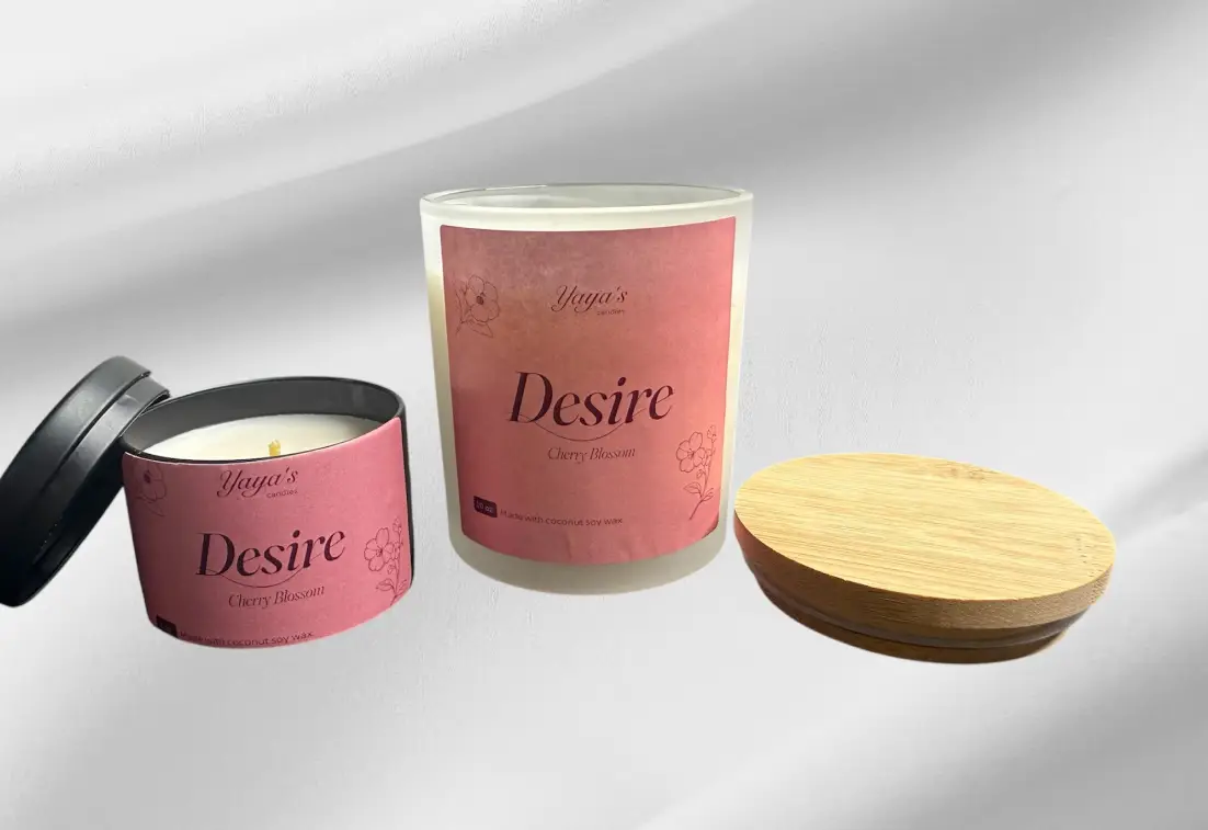 Cherry-blossom-product-images-for-front-end web Two candles from Yaya's line, "Desire" in Cherry Blossom scent. One is cylindrical with a wooden lid, the other is a smaller tin.
