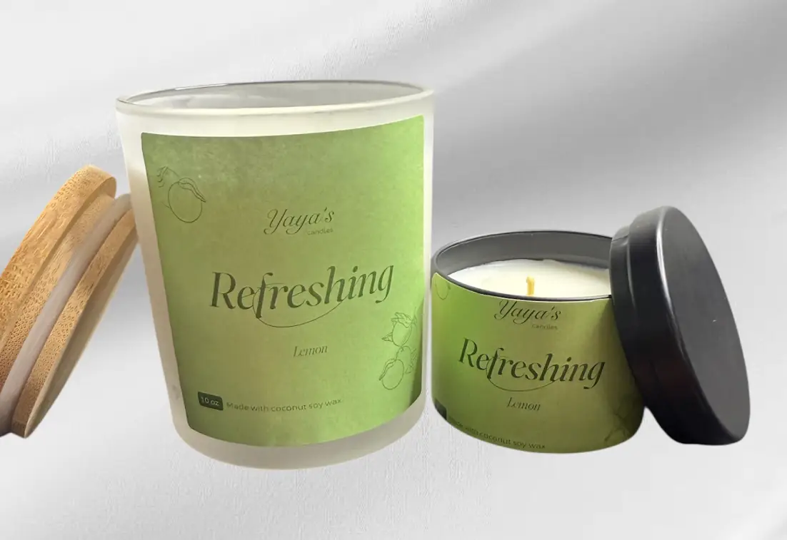 Lemon product-images-for-front-end lemon webp Two lemon-scented candles by Yaya's, one in a glass jar with a bamboo lid and the other in a metal tin, both labeled "Refreshing."