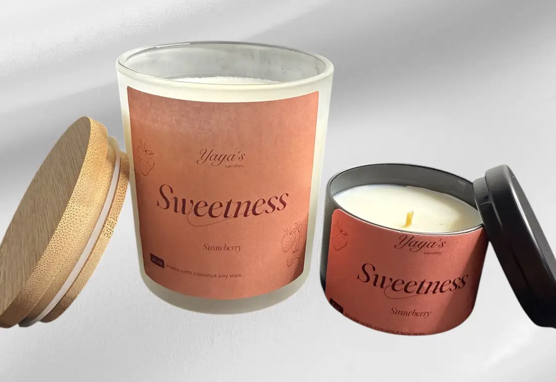 Stawberry-product-images-for-front-end Two candles labeled "Sweetness - Strawberry," one in a glass jar with a wooden lid and the other in a black tin.